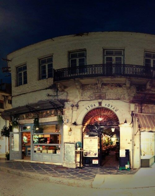 Η φωταγωγημένη παραδοσιακή πέτρινη είσοδος του ρεμπετάδικου Στοά Λούλη στα Ιωάννινα το βράδυ.